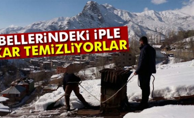 Bellerindeki iple çatılarda kar temizliyorlar