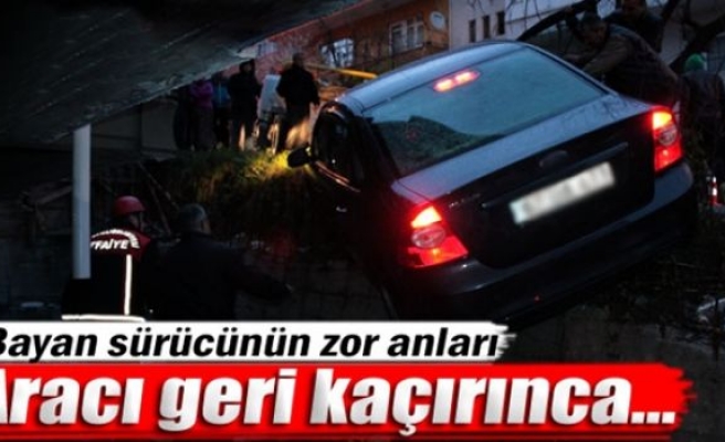 Geri kaçırdığı aracı duvarda asılı kaldı