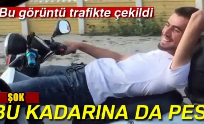 Sırt üstü yatarak motosiklet kullanıyor